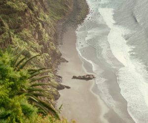 Breathtaking aerial view of Tenerife's dramatic cliffs and serene ocean waves along the coastline.