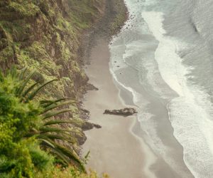 Breathtaking aerial view of Tenerife's dramatic cliffs and serene ocean waves along the coastline.
